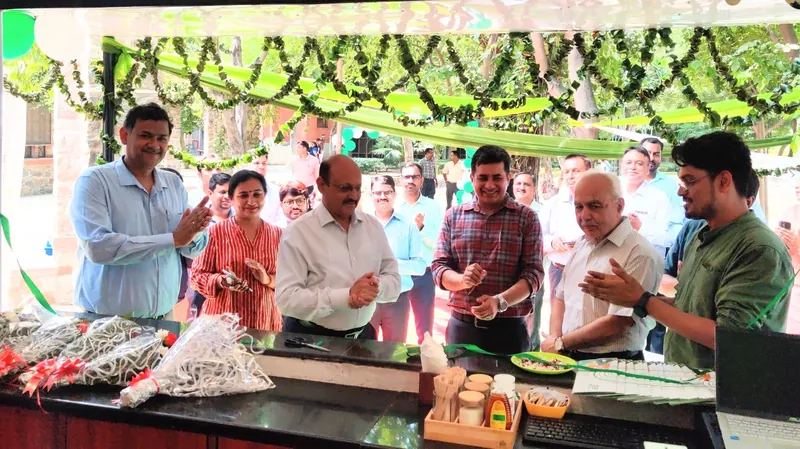 Guests and staff applauding behind a kiosk counter decorated with leaf garlands and green drapes